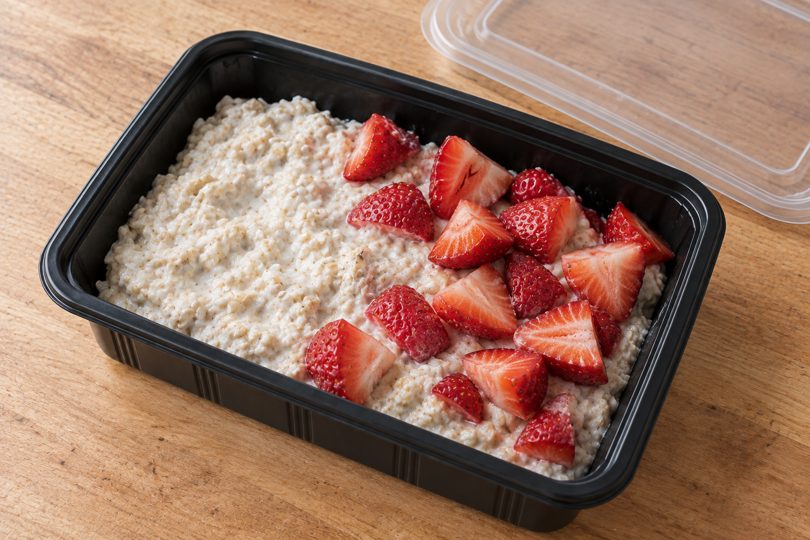 Avena remojada con yogurt y frutillas en envase negro; imagen ilustrativa del recetario